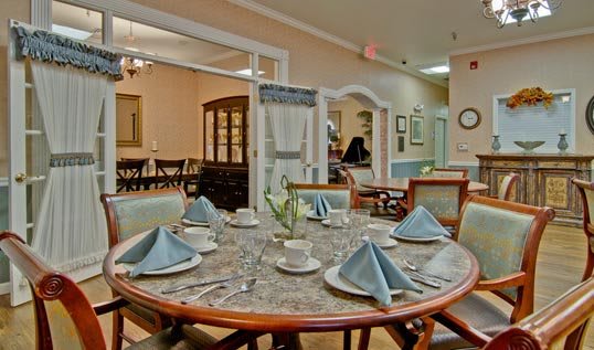 A well-set dining table with blue napkins in a cozy restaurant interior.
