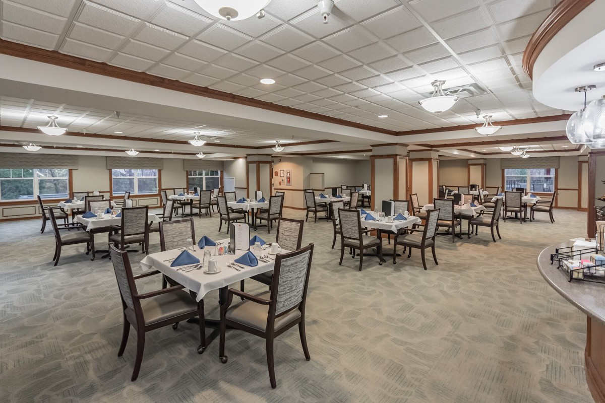Spacious dining area with elegantly set tables and comfortable seating.