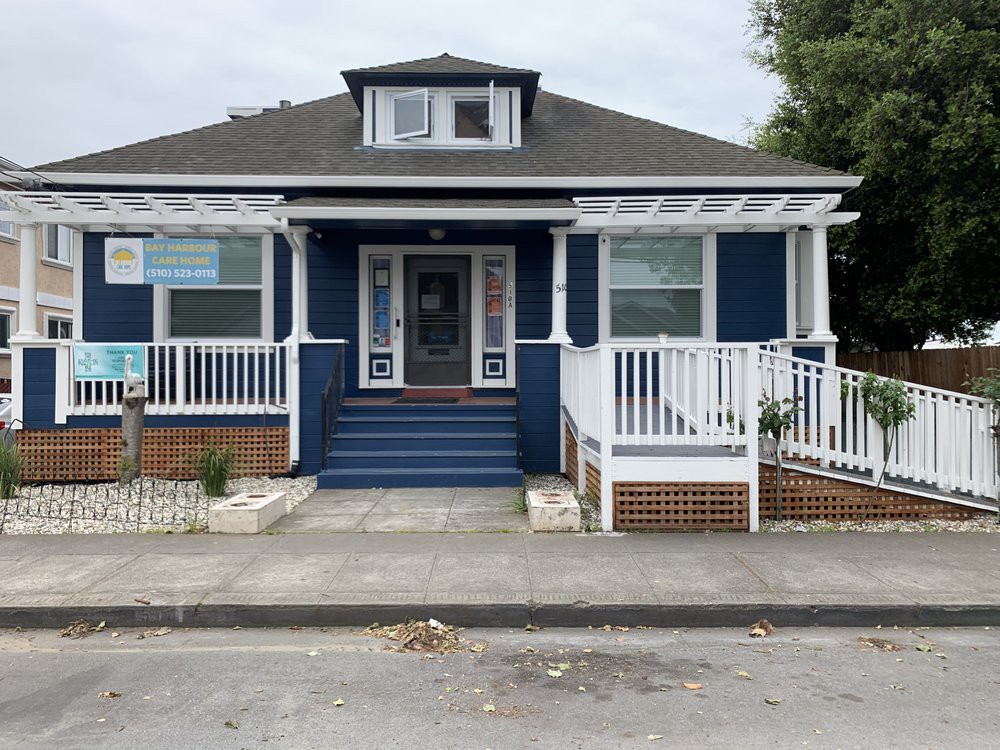 A charming blue bungalow with a welcoming front porch and steps.