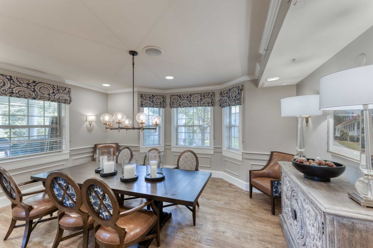 A well-appointed dining room with elegant dcor, featuring a large table, leather chairs, and a modern chandelier.