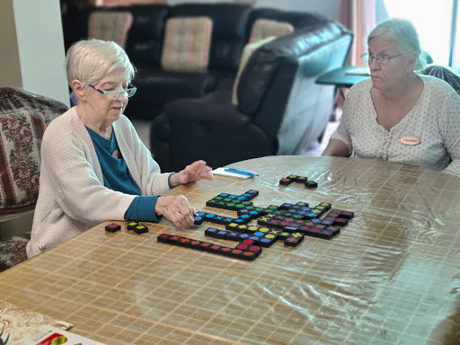 Two elderly women enjoying a board game together.