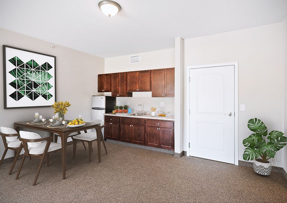 A cozy kitchen and dining area with wooden cabinets and a small dining table set.