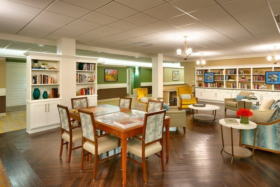 A cozy library reading room with comfortable seating and well-stocked bookshelves.