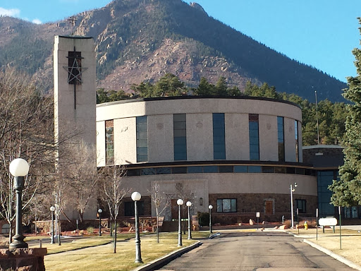 A modern building set against a mountainous backdrop.