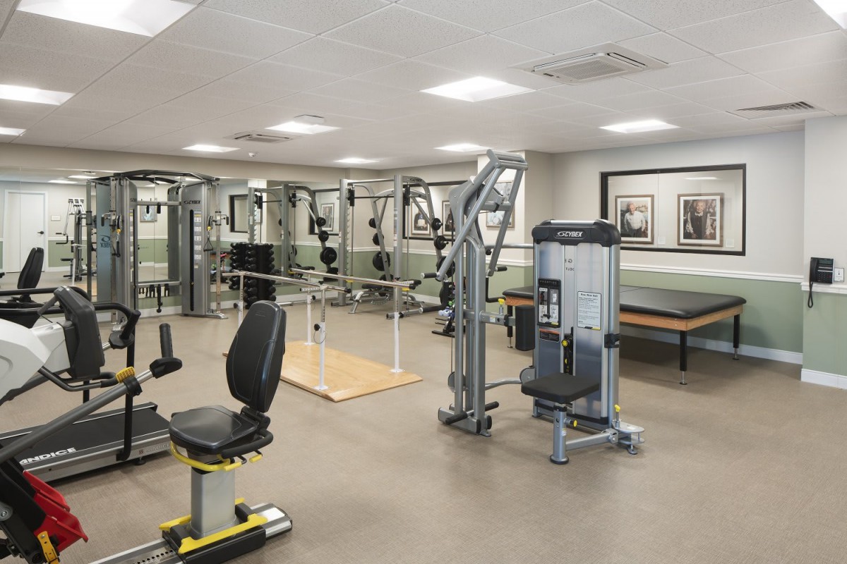 An indoor gym with various exercise machines and equipment.