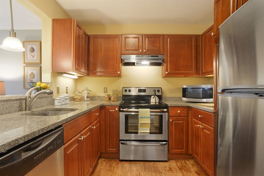A modern kitchen featuring wooden cabinets and stainless steel appliances.