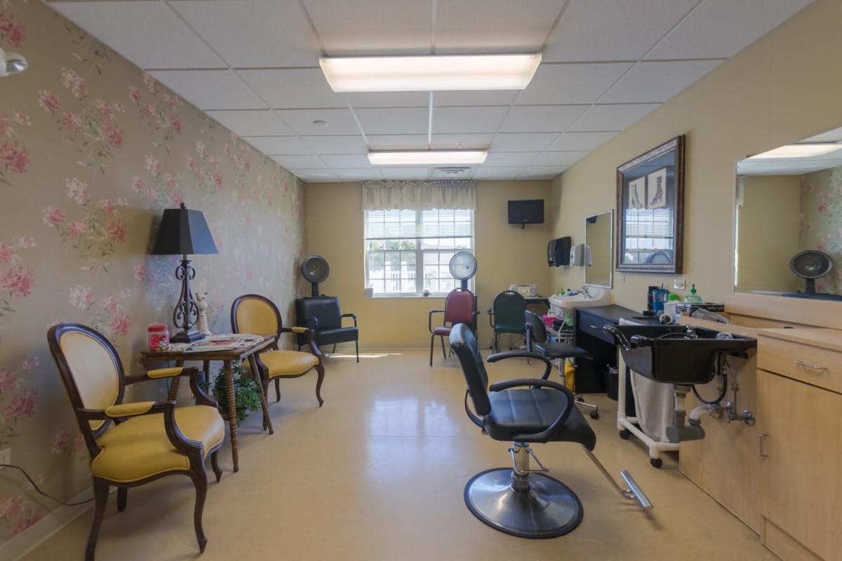 A brightly lit hair salon with chairs, mirrors, and a waiting area.