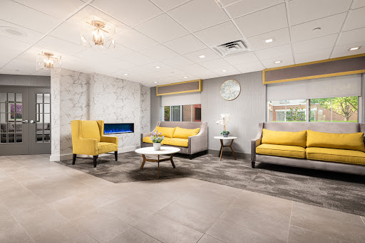 A modern lounge area featuring stylish yellow chairs and a contemporary design.