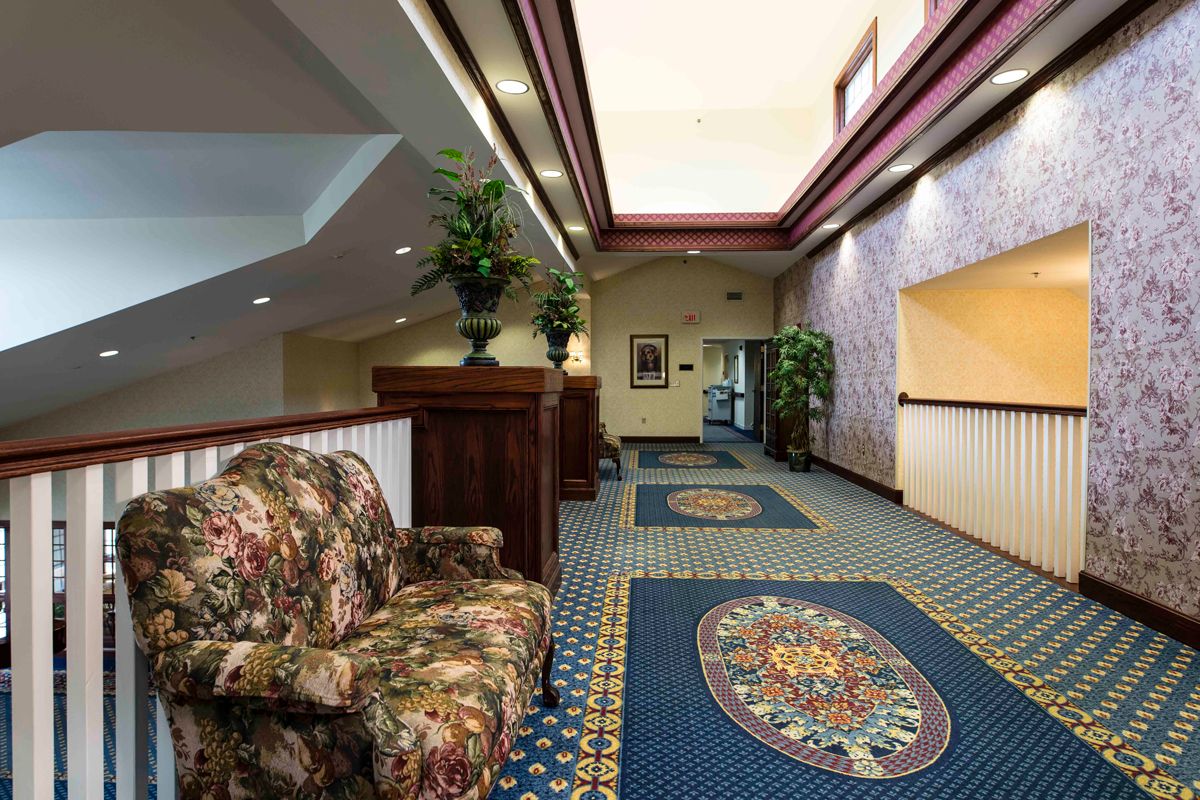 A well-decorated hallway with patterned carpet and comfortable seating.