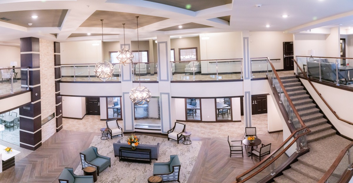 A spacious, elegantly designed lobby featuring chandeliers and comfortable seating areas.