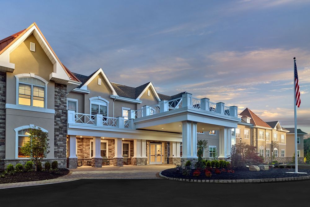 A beautifully designed residential building with a grand entrance at dusk.