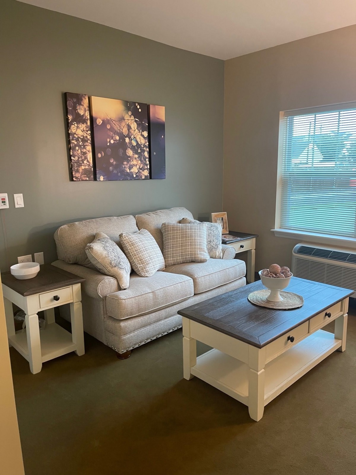 A cozy living room with a sofa, side tables, and coffee table.