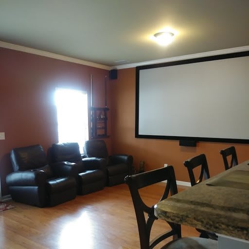 A cozy home theater with recliner seating and a large projection screen.