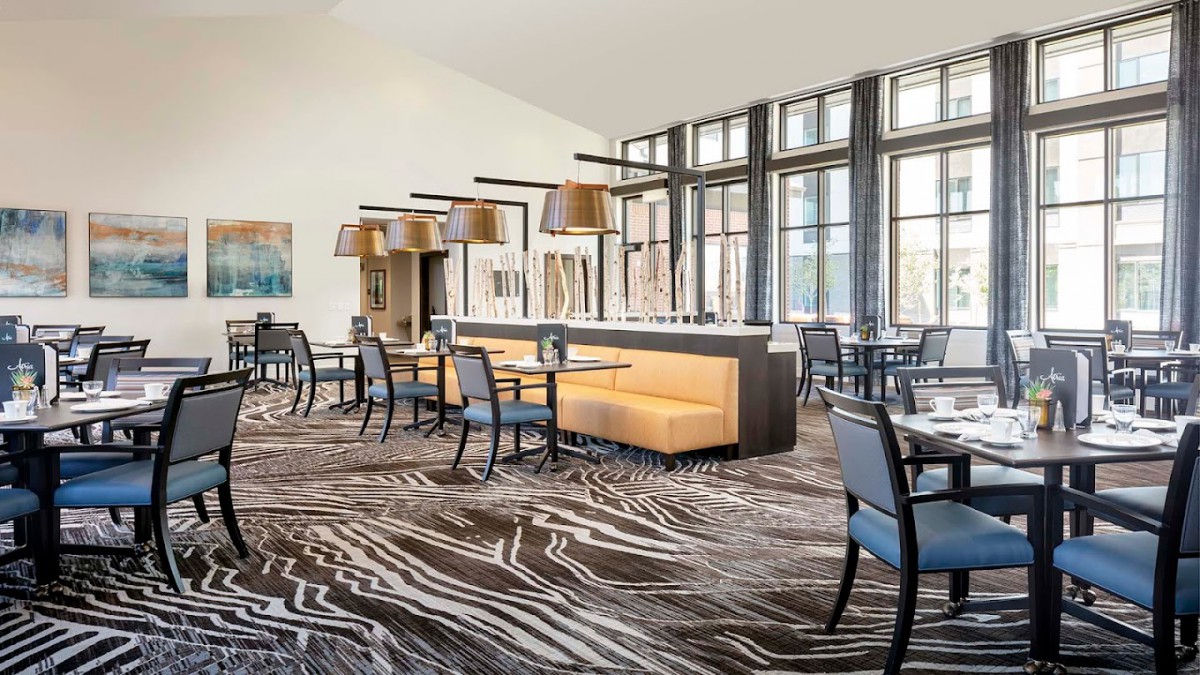 A modern restaurant dining area with stylish furniture and large windows.