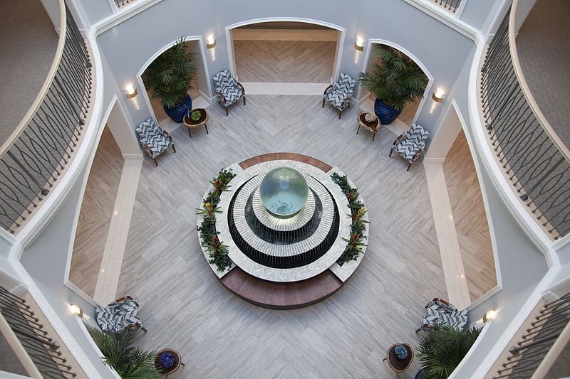 Aerial view of a circular atrium featuring a central fountain surrounded by seating and plants.
