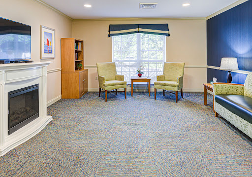 A cozy lounge area with two chairs, a small table, and natural light coming through the window.