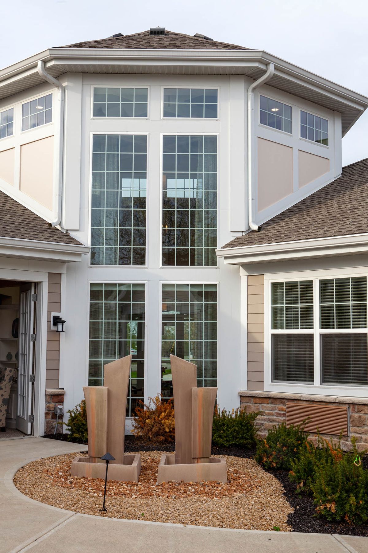 A modern residential building with large symmetrical windows and a well-maintained exterior.