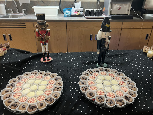A festive display featuring nutcracker figurines flanking two beautifully arranged dessert platters.