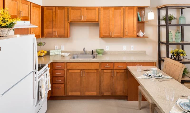 A clean and organized kitchen with wooden cabinets and modern appliances.