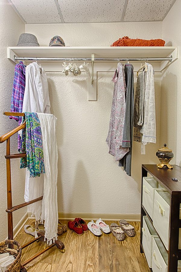 A neatly organized closet with clothes hanging on hangers.