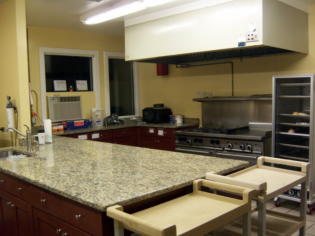 A spacious kitchen with a granite countertop and modern appliances.