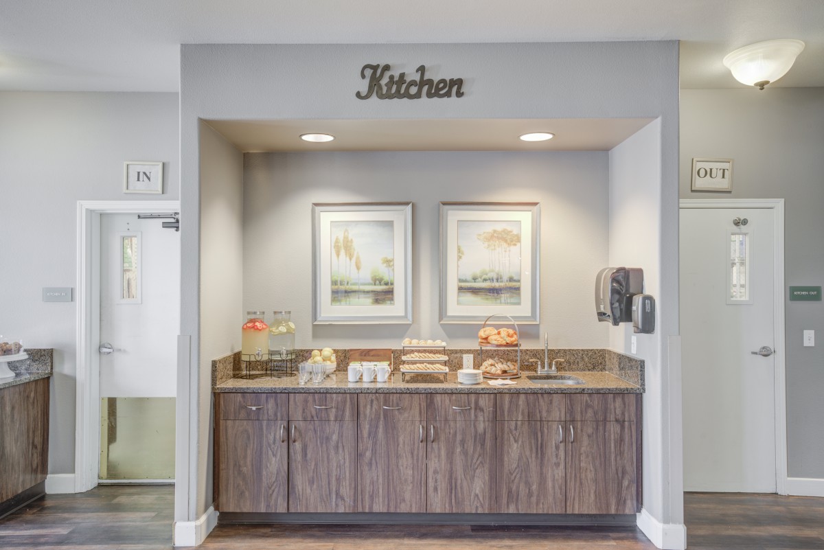 A cozy kitchen nook featuring a snack and coffee station with decorative artwork.