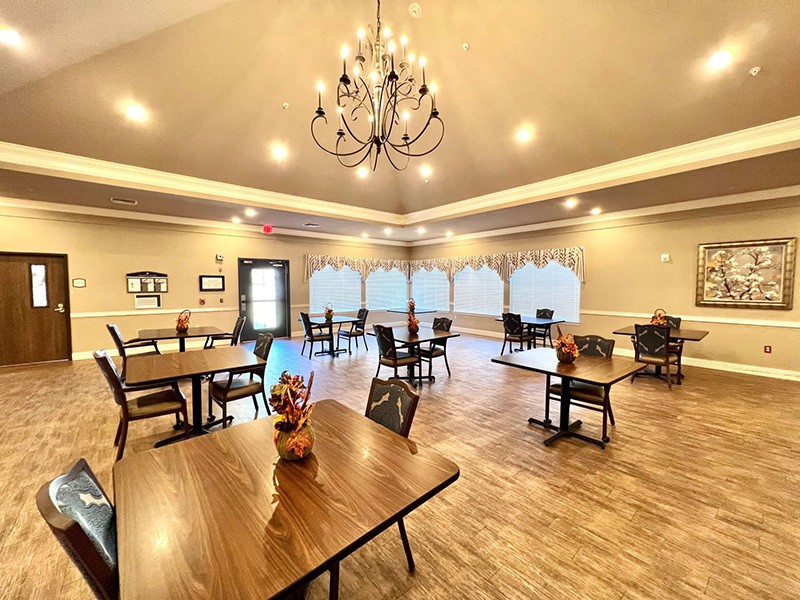 A spacious dining room with elegant lighting and neatly arranged tables.