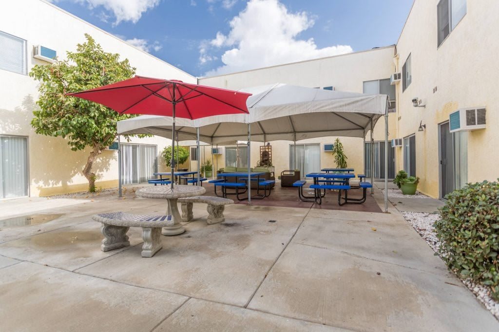 A spacious outdoor patio with seating and umbrellas in a courtyard setting.