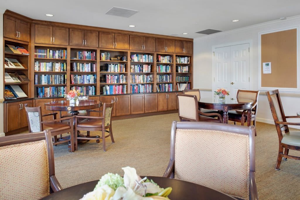 A cozy library with wooden bookshelves and comfortable seating for reading.