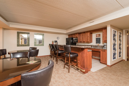 A modern kitchen and dining area featuring wooden cabinetry and bar seating.