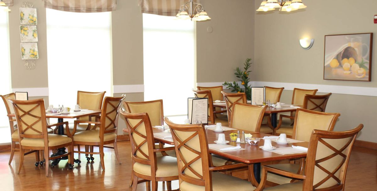 A well-lit restaurant dining area with neatly arranged tables and chairs.