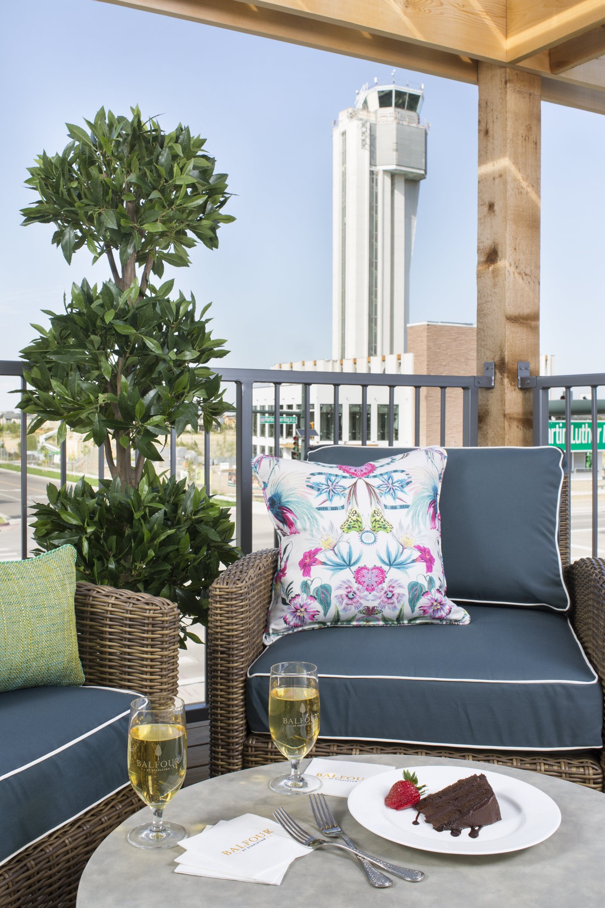 A cozy outdoor patio with wicker furniture and colorful cushions, perfect for relaxing in an urban setting.