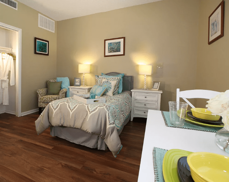 A cozy bedroom with a single bed, neatly arranged decor, and warm lighting.