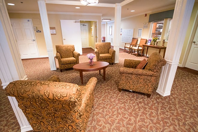 A cozy living room with patterned armchairs arranged around a wooden coffee table.