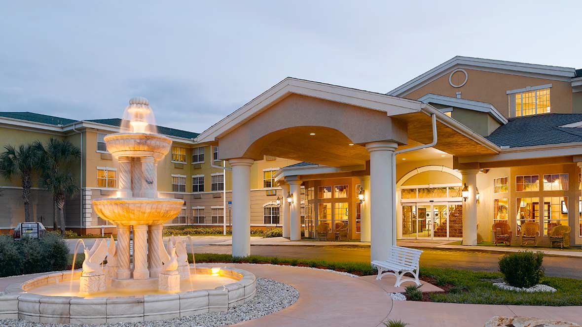 An elegant building entrance with a fountain and columns.