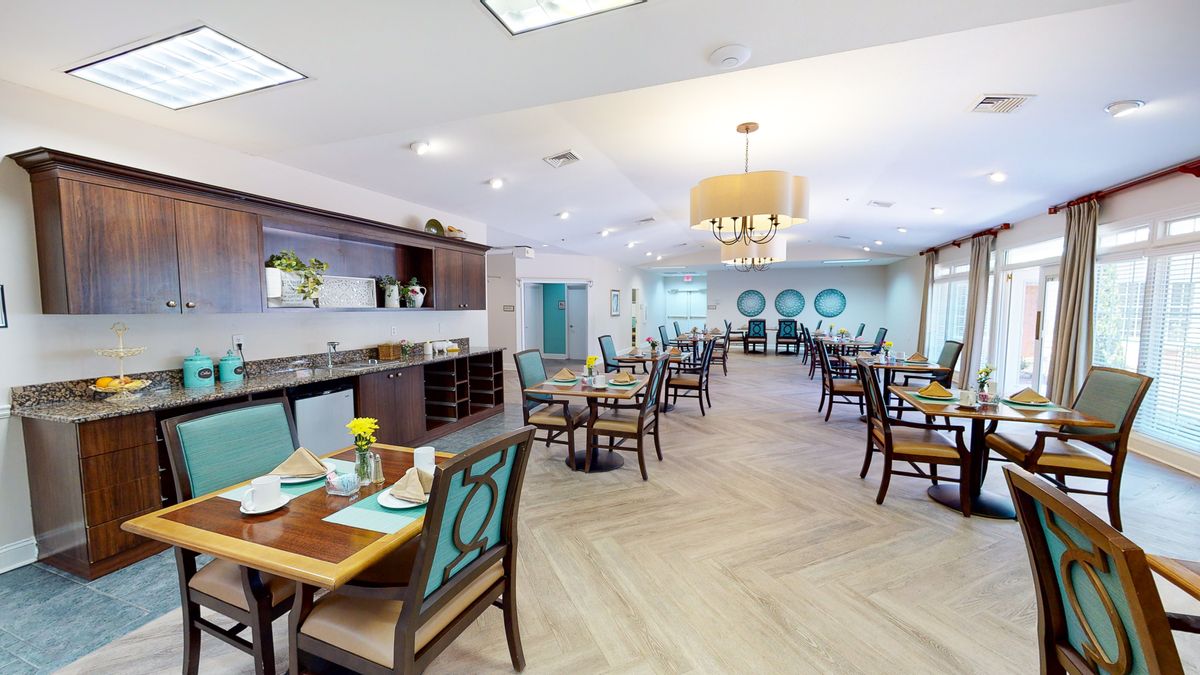 A modern dining room interior with neatly arranged tables and chairs, featuring stylish decor.