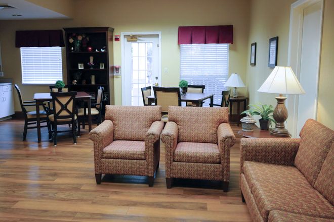 A cozy living room with patterned chairs, a round table, and soft lighting.
