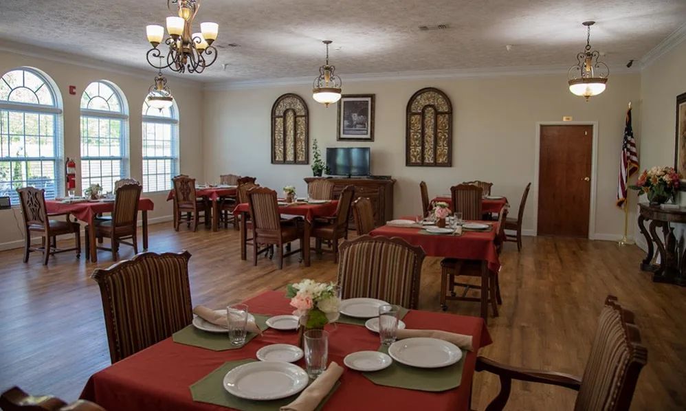 A formal dining area with neatly arranged tables and chairs, featuring elegant decor and well-set tableware.