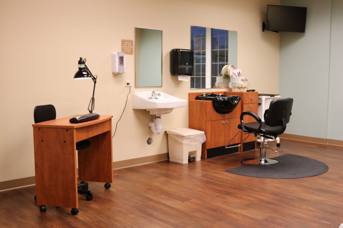 A well-equipped salon station with a barber chair, sink, and styling tools.