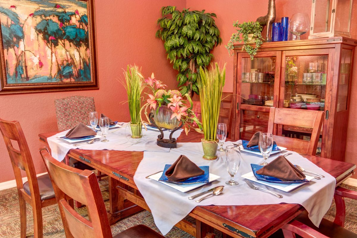 A beautifully set dining table with elegant dinnerware and floral centerpieces.