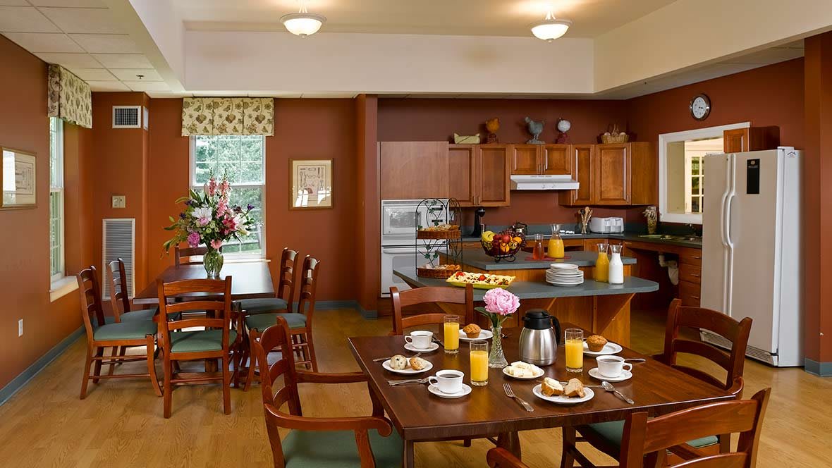A cozy kitchen and dining area with breakfast setup including orange juice and coffee.