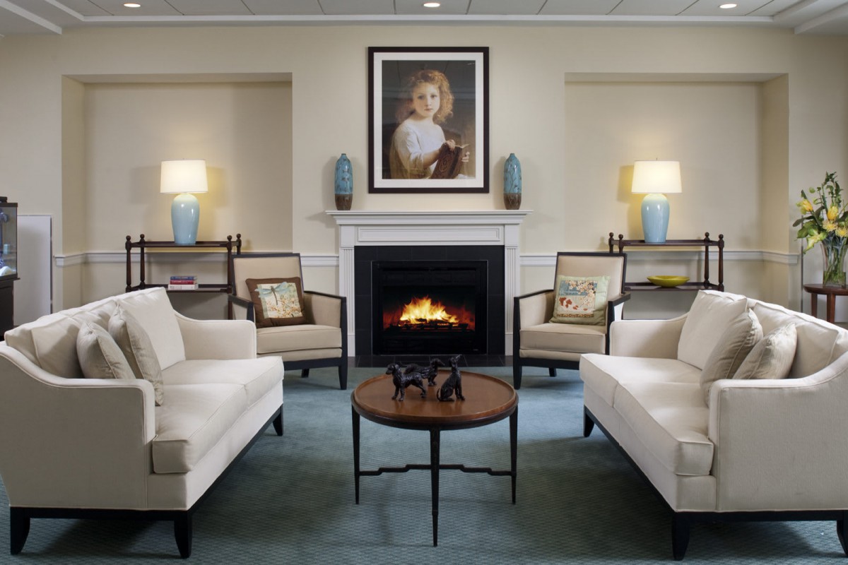 A cozy living room featuring a central fireplace, comfortable seating, and elegant decor.