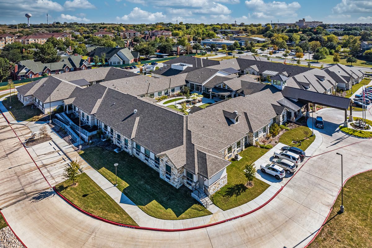 Aerial view of a suburban residential complex with multiple buildings and parking spaces.
