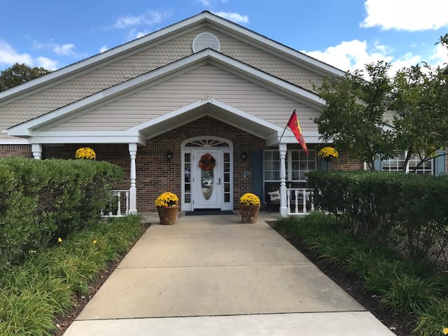 A cozy house with a welcoming entrance, lined with flowers and a small flag on the porch.