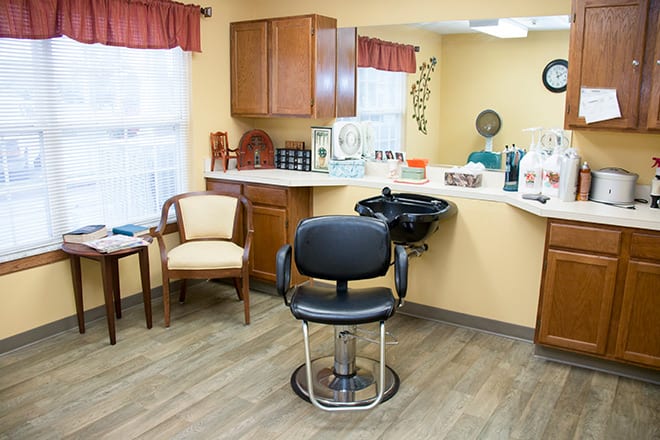 A cozy hair salon with a barber chair, sink, and waiting area.