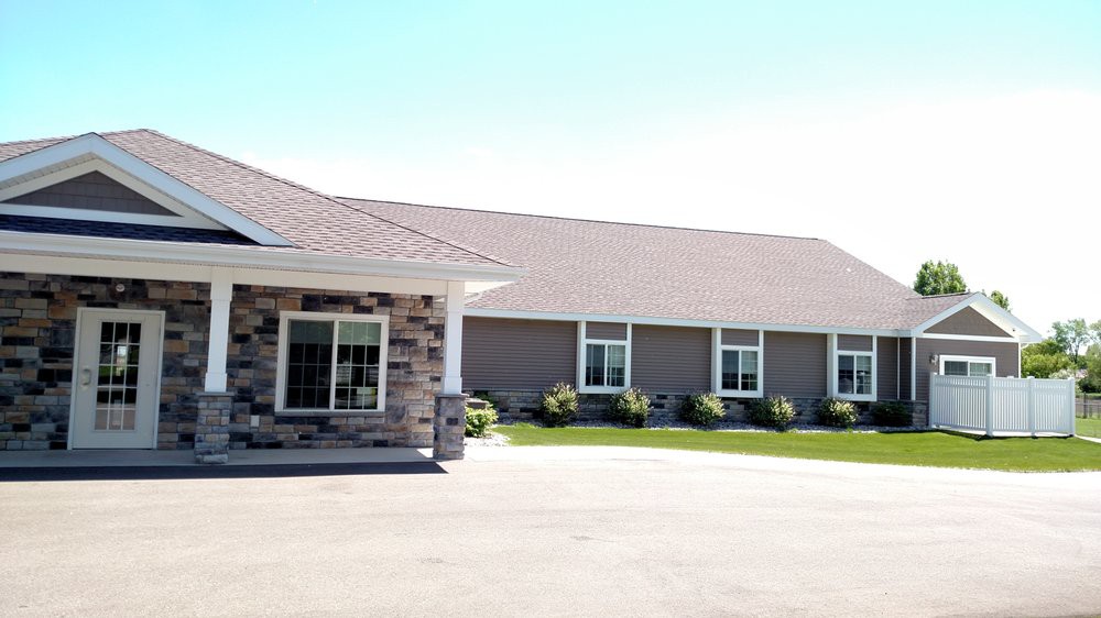 A commercial building on a sunny day with a large driveway.