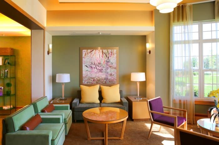 A modern living room with colorful furniture and decorative artwork.