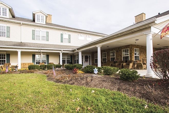 A two-story house with a wide porch and well-maintained lawn.