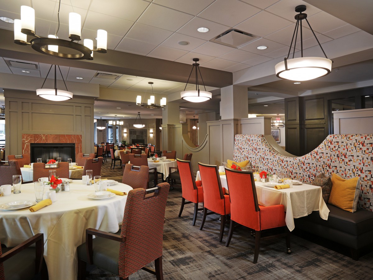 A well-lit restaurant dining area featuring neatly arranged tables and chairs with elegant decor.