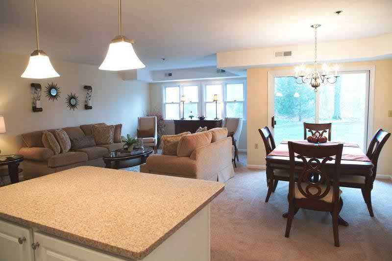 A cozy open floor plan living and dining area with comfortable seating and elegant lighting.